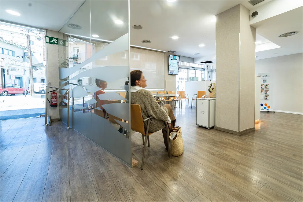 Interior de la sala de espera de la clínica Can Mora con luz natural y diseño funcional; clínica oftalmológica en Sant Cugat.