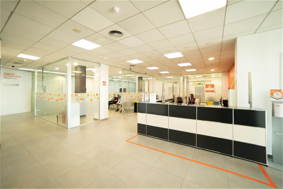 Zona de recepción y consultas acristaladas en Àptima Centre Clínic; servicios avanzados de oftalmología en Sant Cugat del Vallès.