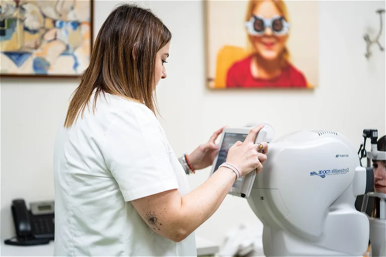 Profesional de oftalmología pediátrica ajustando un equipo de exploración visual en consulta para la evaluación ocular infantil.