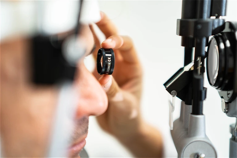 Profesional realizando un examen ocular clínico exhaustivo con lente diagnóstica, paso esencial en el estudio previo para el tratamiento de ortoqueratología (Orto-K).