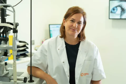 Rebeca Barricarte Rivas, del equipo Oftalmediq, junto a una lámpara de hendidura para la exploración detallada del ojo.