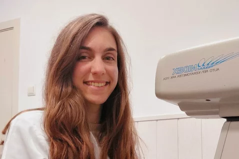 Rut Ferran Piqueras de Oftalmediq junto a un autorrefractómetro Nidek para la medición precisa de la graduación visual.